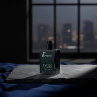 fragume Anure parfum for men in a deep forest green glass bottle on a slate base against a city window backdrop
