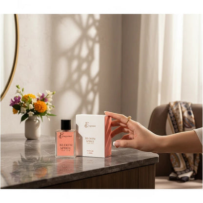 fragume Bloom Spirit Eau De Parfum bottle and box on a marble vanity with a floral bouquet in the background