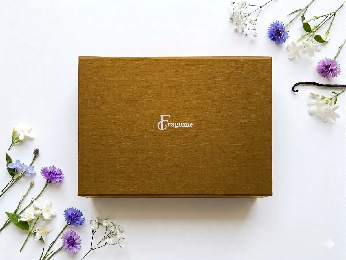 fragume 4 pocket perfume set in a gold textured gift box surrounded by delicate purple and white flowers