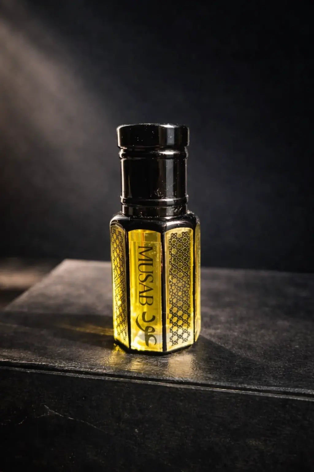 fragume Musab concentrated perfume oil in an artisanal glass bottle with intricate geometric patterns on a dark surface