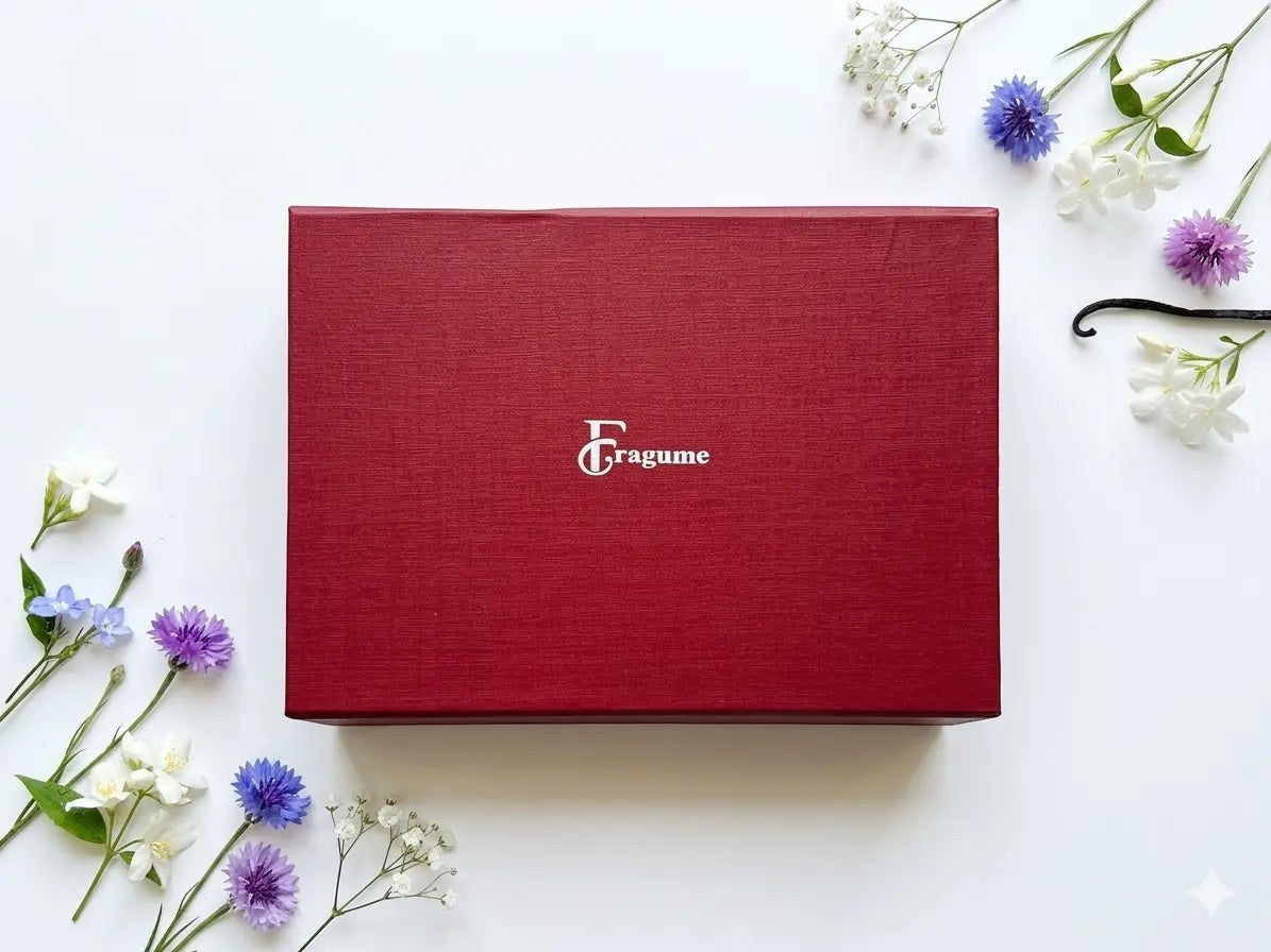 fragume 4 Pocket Perfume Set in a textured deep red gift box surrounded by delicate blue and white flowers