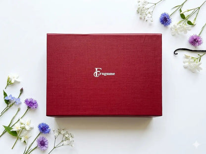 fragume 4 Pocket Perfume Set in a textured deep red gift box surrounded by delicate blue and white flowers