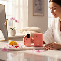 fragume Secret Crystal parfum bottle and box on a marble tray with lemons and petals, held by a woman in a robe.